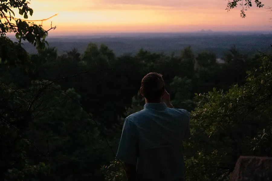 Man viewing the Charlotte skyline at sunset from Spencer Mountain